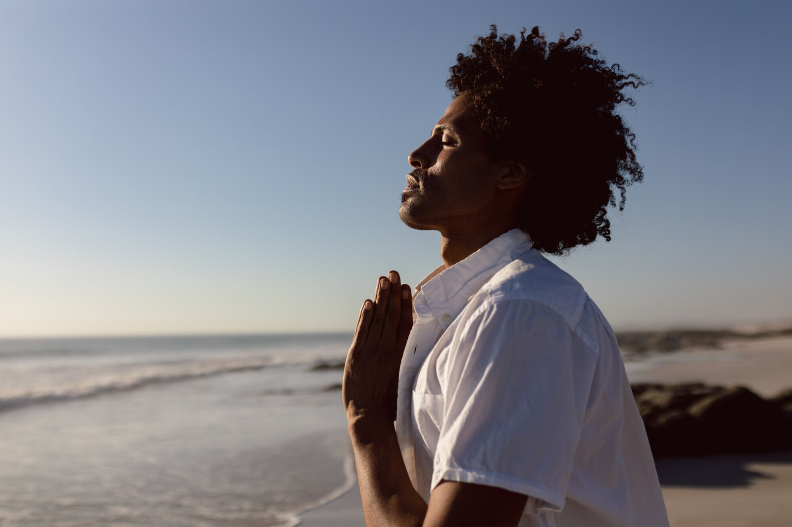 Homem em oração na praia - Ver filmes sobre espiritualidade